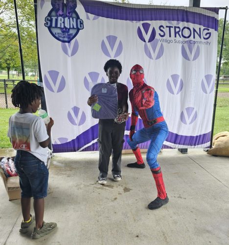 Spiderman posing with boy during back to school backpacks giveaway in Detroit