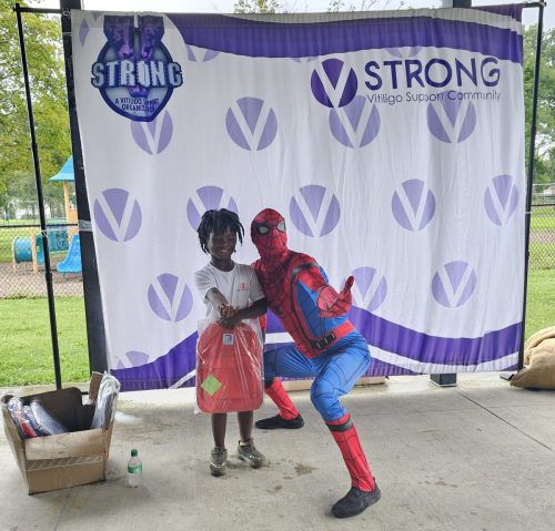 Spiderman posing with boy during back to school backpacks giveaway in Detroit 