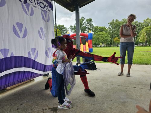 Spiderman posing with girl during Back to School backpacks giveaway in Detroit